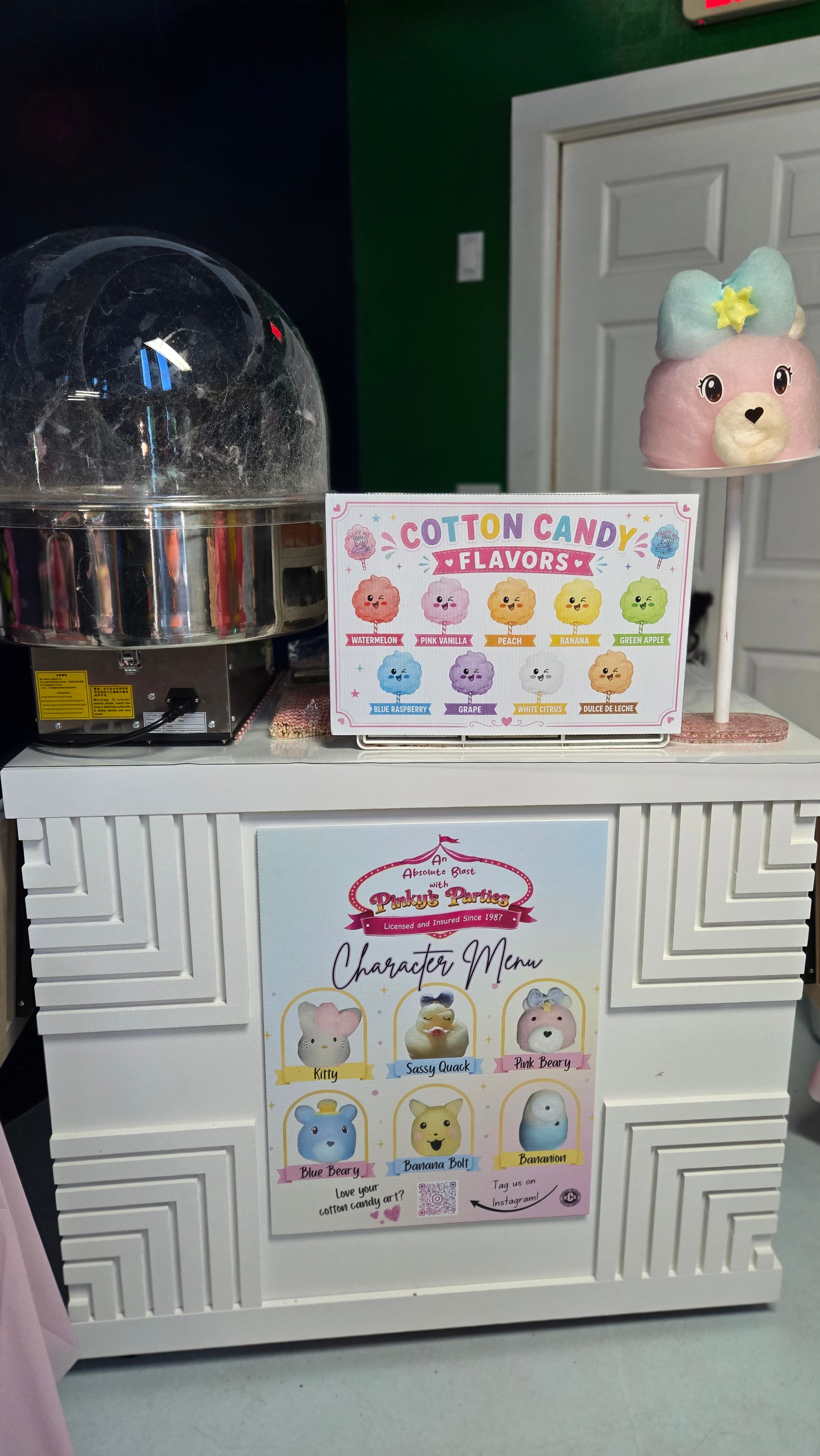Cotton candy station featuring flavor and character menus alongside a pink bear-shaped treat.